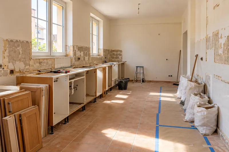 Visualización conceptual IA: Retirada de muebles y revestimientos al comienzo de una reforma de cocina.